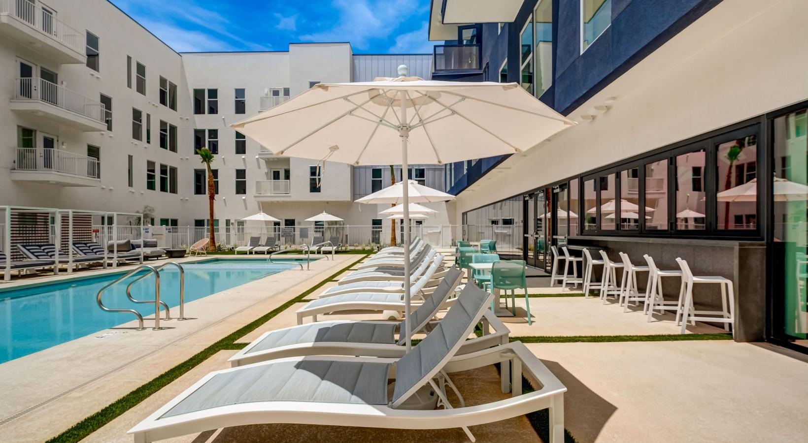 Relax and unwind poolside a pool with chairs and umbrella