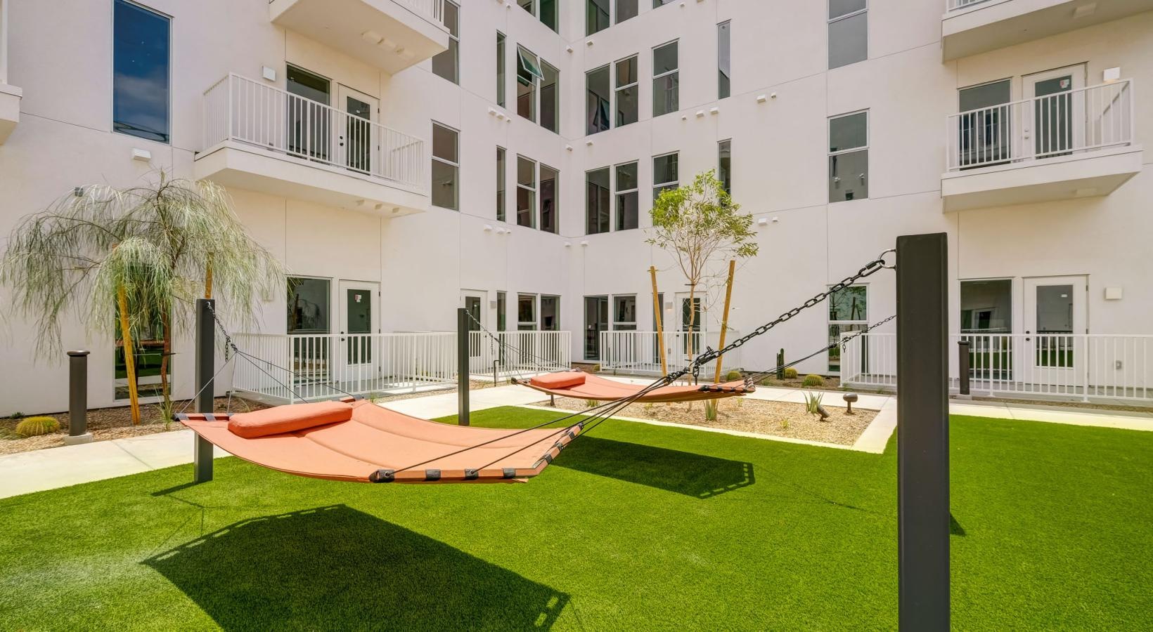 Find your perfect fit at The Pomeroy a building with a lawn and hammocks