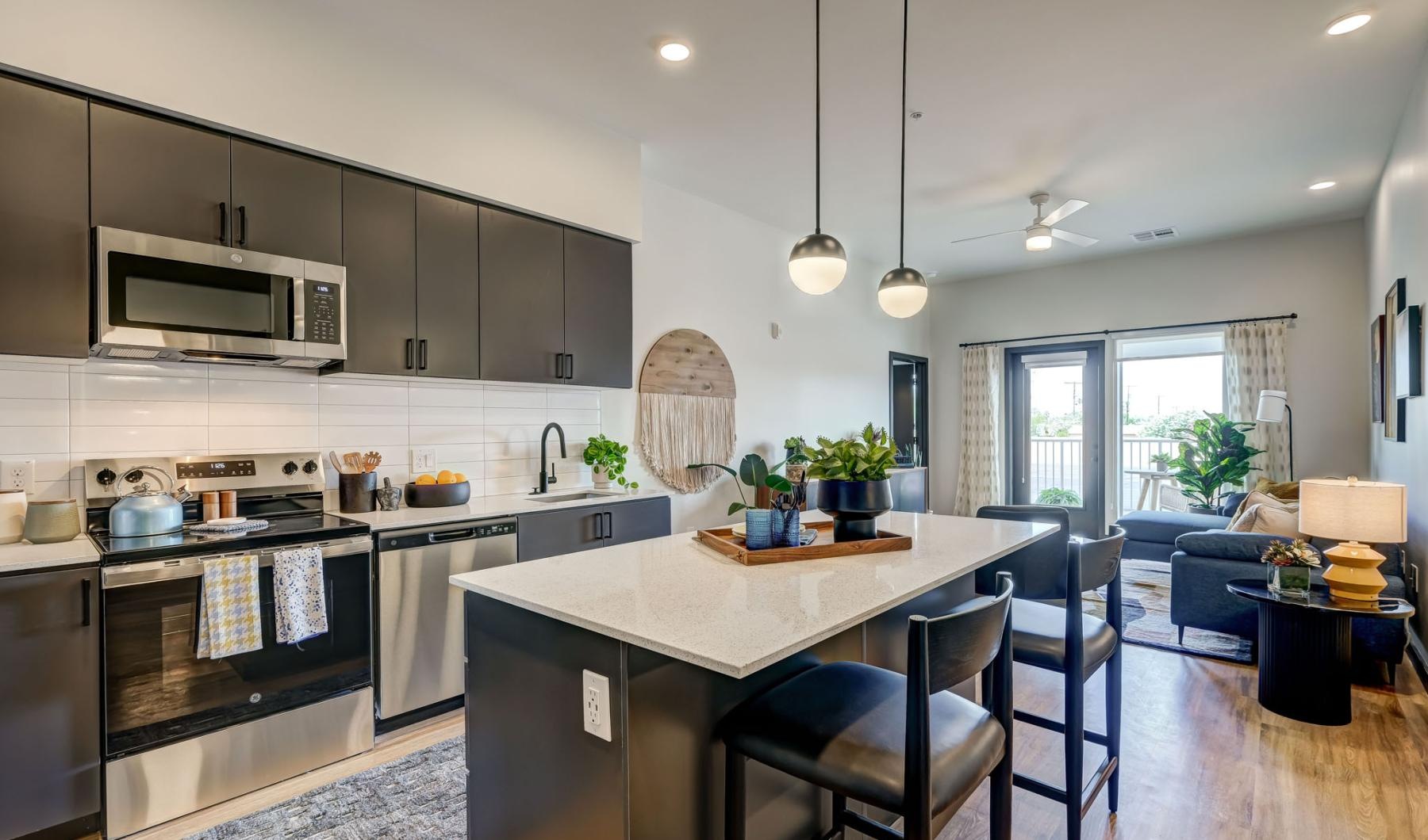 Beautiful living areas to match your lifestyle a kitchen with a bar and chairs