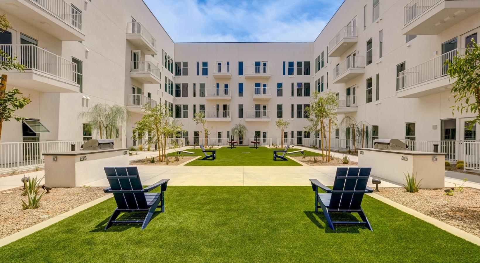 Enjoy our resident-only features a lawn with chairs and trees in front of a building