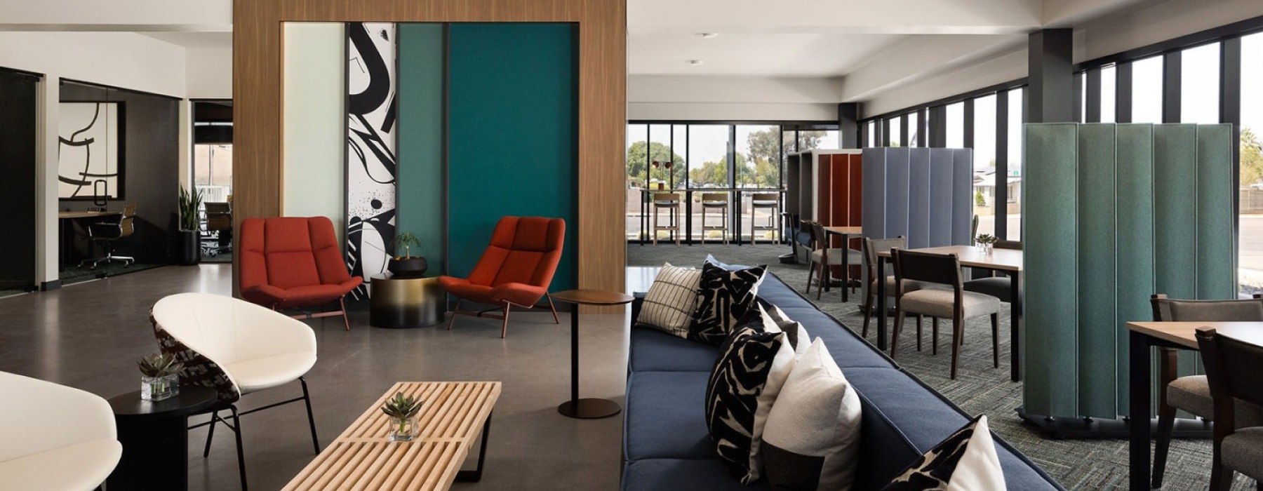 Upscale resident lounge at The Pomeroy in Mesa, AZ, featuring mid-century modern furniture, a long blue sectional, and designer coworking spaces.