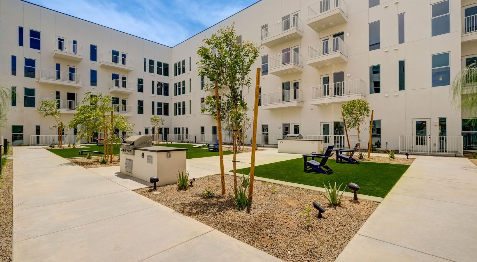 Settle into comfort at The Pomeroy a courtyard with trees and grass in front of a building