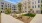 a courtyard with trees and grass in front of a building